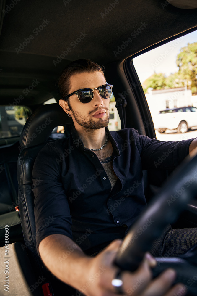 vertical shot of handsome elegant man with sunglasses sitting behind steering wheel, fashion concept vertical shot of handsome elegant man with sunglasses sitting behind steering wheel, fashion concept