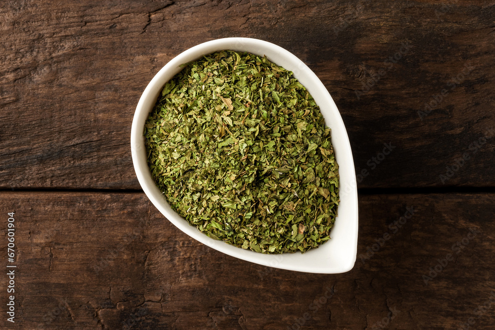 Dried lovage in bowl on retro wooden background. Top view Dried lovage in bowl on retro wooden background. Top view
