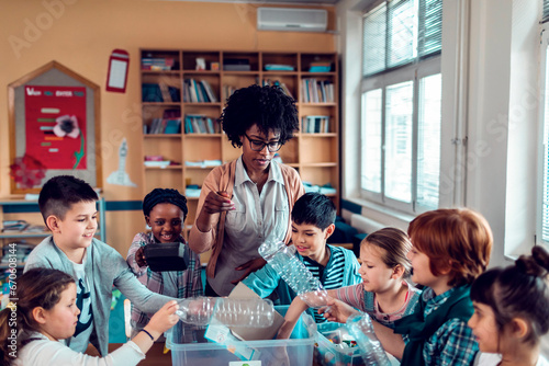 A teacher guides students in a recycling activity in the classroom photo