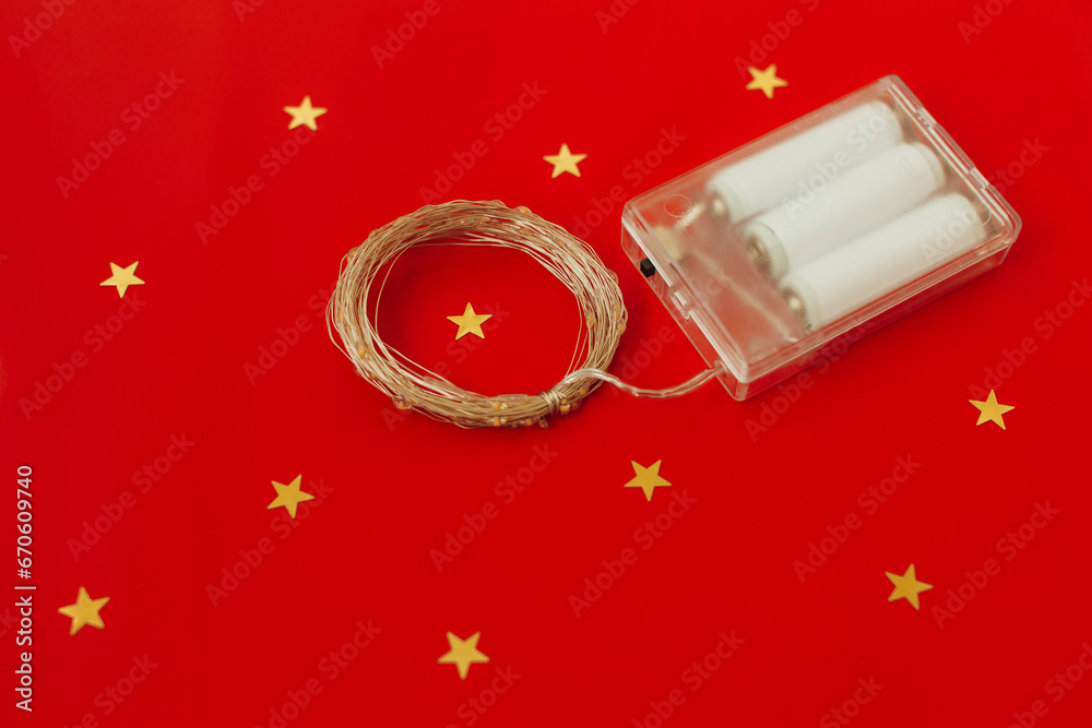 Led lights decorative garland on red background. Christmas holidays and electrical appliances concept