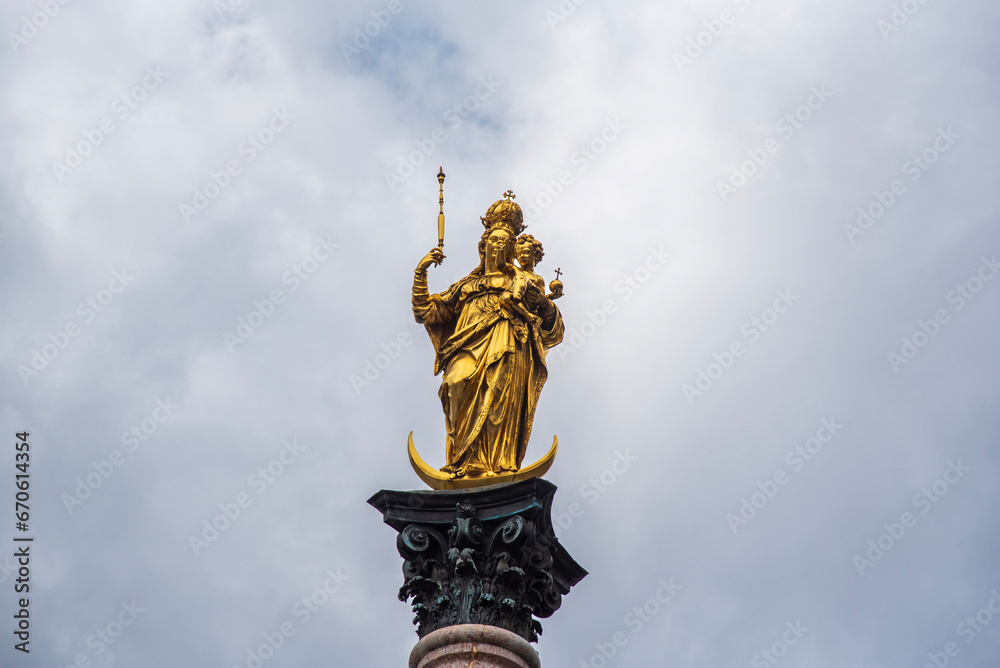 Golden statue of Mary on top of Mariensaule located on the Marienplatz in Munich Golden statue of Mary on top of Mariensaule located on the Marienplatz in Munich