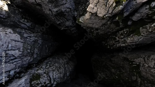 The drone flies out of a bottomless 188 meter pit into a plateau. Nikolina pit. Montenegro. Aerial view.