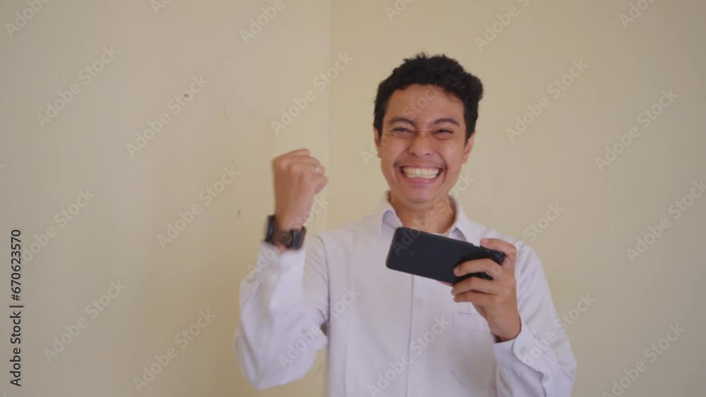 Indonesian office employee wear white clothes unhappy playing game when working hour. The footage is suitable to use for man expression and daily life content media. Indonesian office employee wear white clothes unhappy playing game when working hour. The footage is suitable to use for man expression and daily life content media.