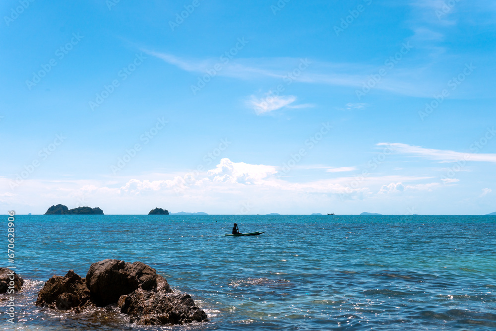 Blue sea wave crashing against rocky stone cliff Islands. Lonely fisherman Blue sea wave crashing against rocky stone cliff Islands. Lonely fisherman
