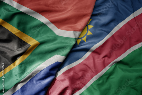 big waving national colorful flag of south africa and national flag of namibia . photo