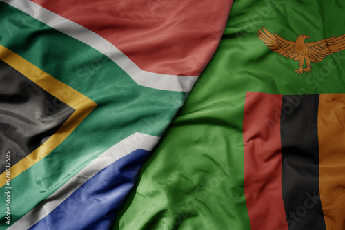 big waving national colorful flag of south africa and national flag of zambia .