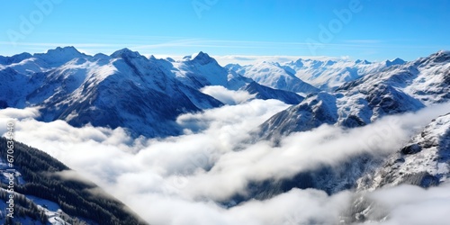 panoramic view of snowy mountains in the clouds on a sunny day