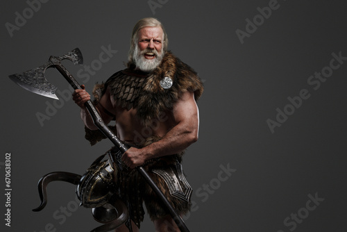 A furious screaming elderly Viking with long white hair and a beard, dressed in fur and light armor against a gray background