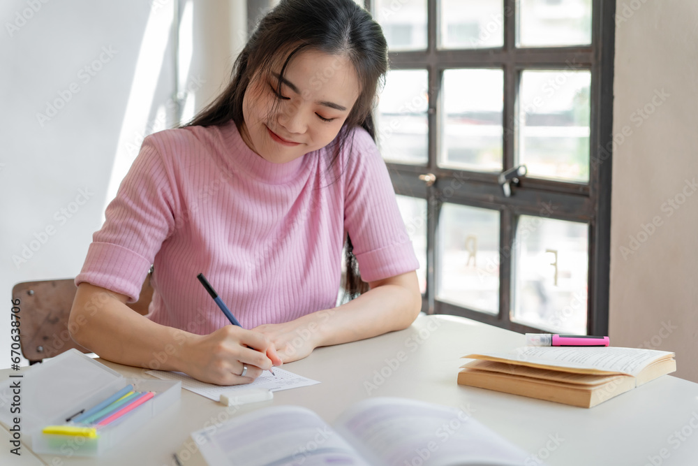 Asian girl student doing exam hand holding pencil writing answe Asian girl student doing exam hand holding pencil writing answe