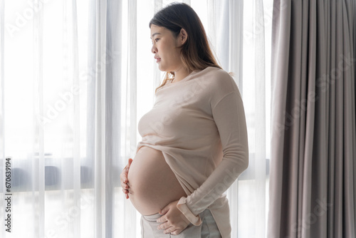 Pregnant asian woman holds hands on belly touching her baby caring about her health Beautiful happy pregnant woman tender mood photo of pregnancy Free Download Pregnant asian woman holds hands on belly touching her baby caring about her health Beautiful happy pregnant woman tender mood photo of pregnancy - GFXLoad
