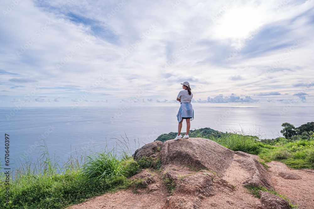 oung woman standing on top of the mountain and looking at the sea Phuket Thailand
