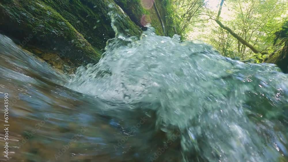 Stream of clear water in a mountain canyon. Close-up. The camera captures the swirling water. Mountain river. Water foaming and splashes flying in different directions Stream of clear water in a mountain canyon. Close-up. The camera captures the swirling water. Mountain river. Water foaming and splashes flying in different directions