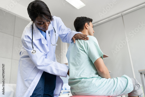 Canvas Print African American Doctor or Physiotherapist working examining treating of caucasi