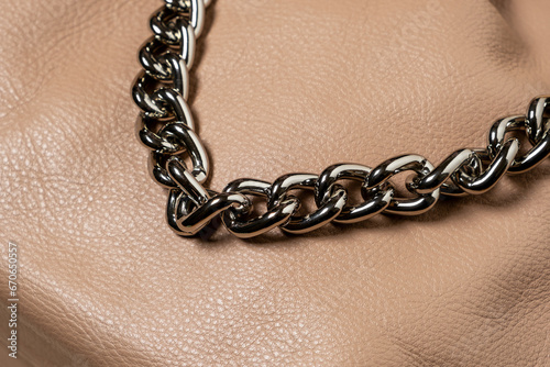Decorative shiny chain on brown leather