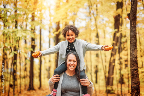 mother and daughter having fun in autumn park