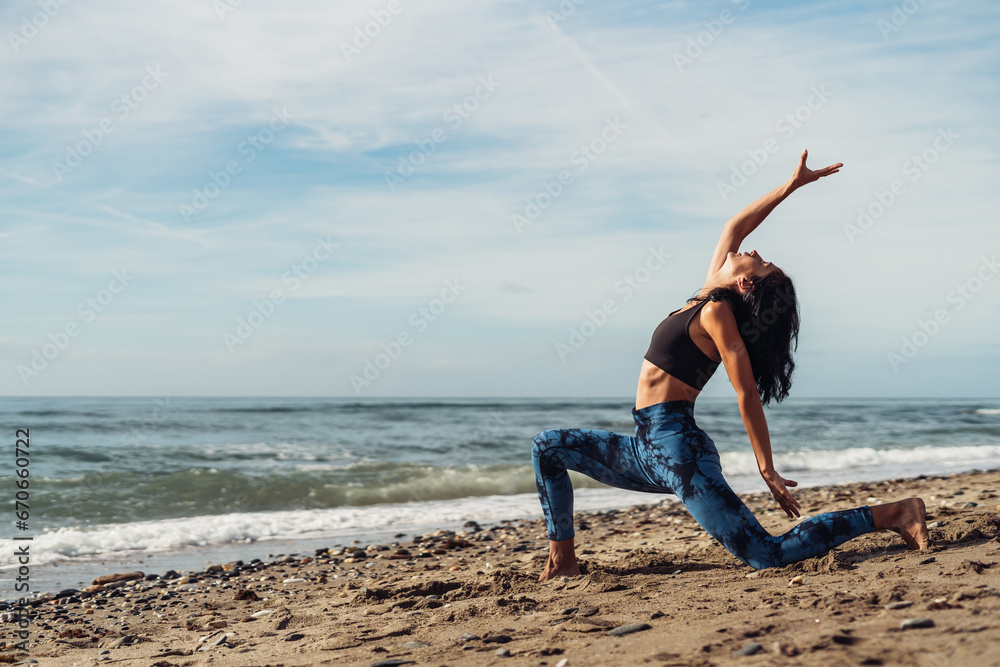 Beautiful athletic brunette girl doing Pilates by the seaside Beautiful athletic brunette girl doing Pilates by the seaside
