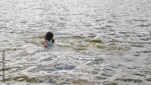 Girl peeping from lake surface at summer nature closeup. Enjoy holidays and summer