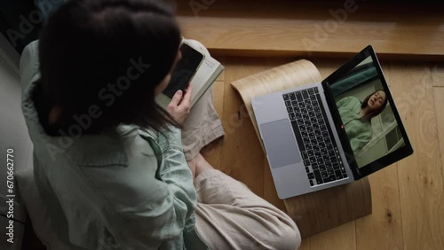 Top view attractive smiling female recording herself for online course and ed program at home sitting on the wooden floor in living room