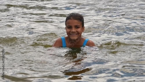 Girl peeping from lake surface at summer nature closeup. Enjoy holidays and summer