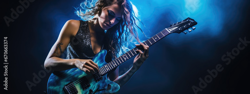 Young female musician playing guitar at a rock concert photo