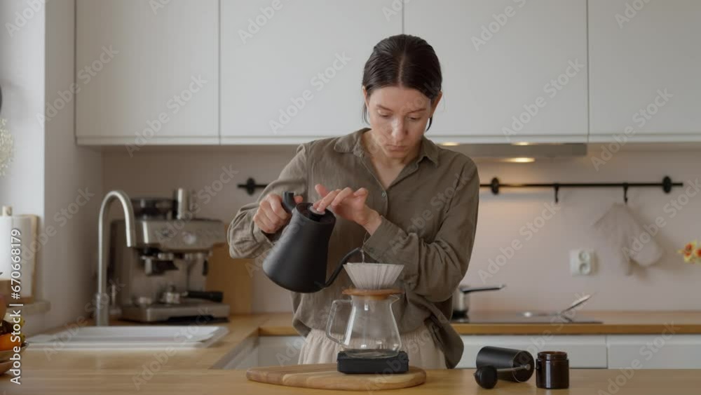 4k video Barista woman pouring hot water over filter with ground coffee in the funnel. Drip filter coffee brewing at home on kitchen. 4k video Barista woman pouring hot water over filter with ground coffee in the funnel. Drip filter coffee brewing at home on kitchen.