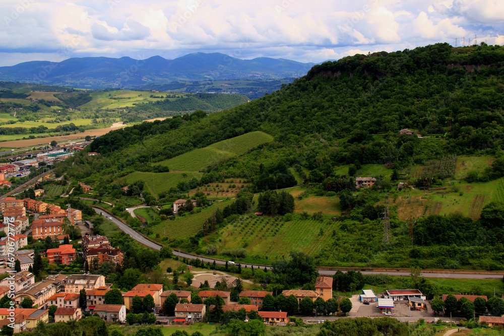 Landscape with green hills and mountains in the background with houses in the foreground in the city of Orvieto, Umbria region, Italy