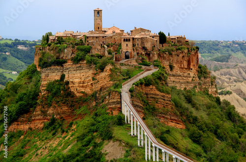 View of the valley and town of Civita di Bagnoregio with stone houses on a high cliff in the province of Viterbo, Lazio region, Italy photo