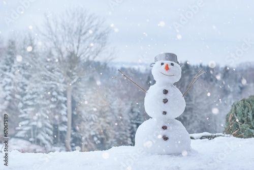 Lovely smiling snowman in the winter landscape. © Tunatura