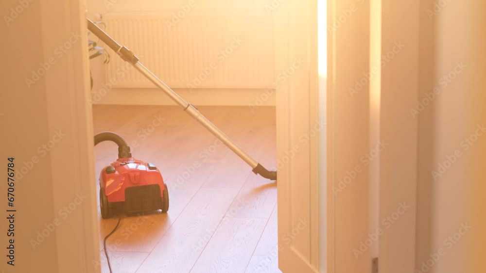 A woman is vacuuming in the living room. Cleanliness in the house A woman is vacuuming in the living room. Cleanliness in the house