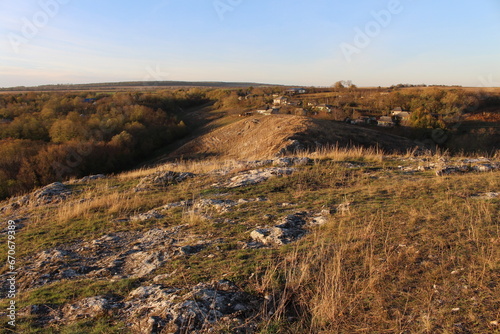 A grassy field with a hill in the background