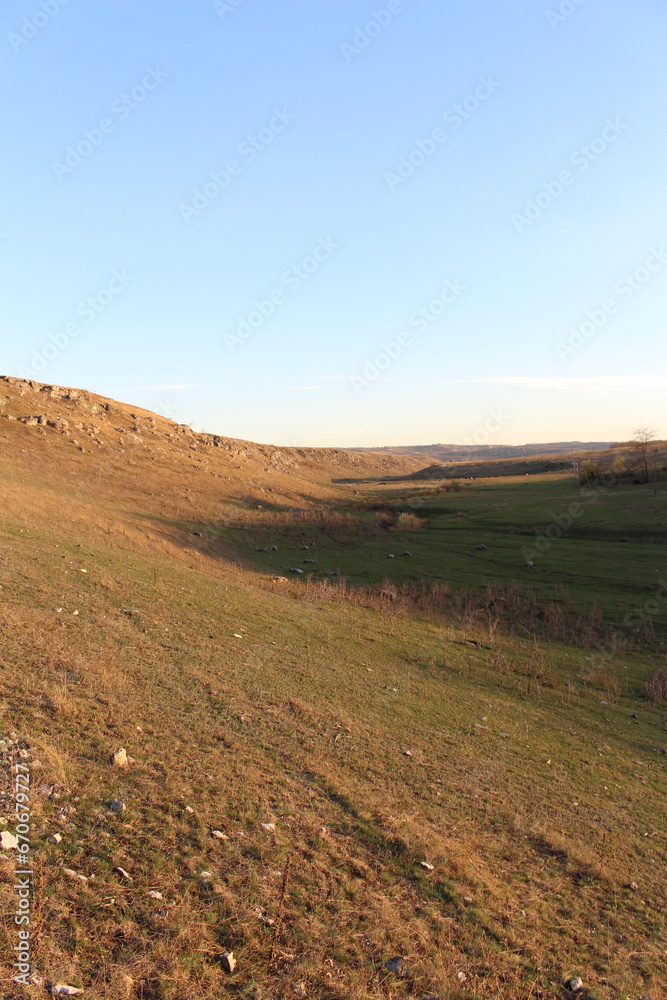 A grassy hill with a blue sky