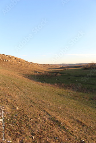 A grassy hill with a blue sky