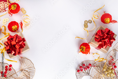 Chinese New Year on white background. Lunar New Year greeting card with traditional festival decoration - ginkgo biloba, golden twigs, gift boxes, red berries, gift envelopes, coins, chinese lanterns