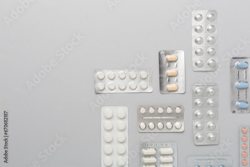 Pills in blister packaging on color background, top view photo