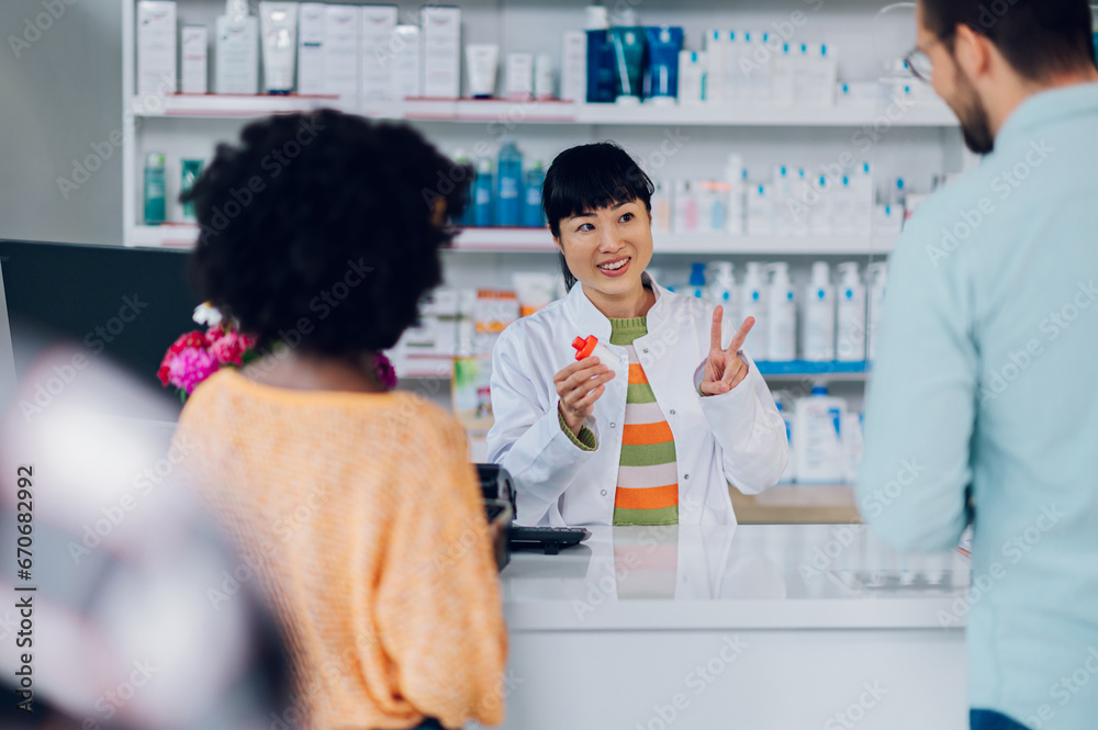 Japanese woman pharmacist selling drugs to a customer in a pharmacy Japanese woman pharmacist selling drugs to a customer in a pharmacy