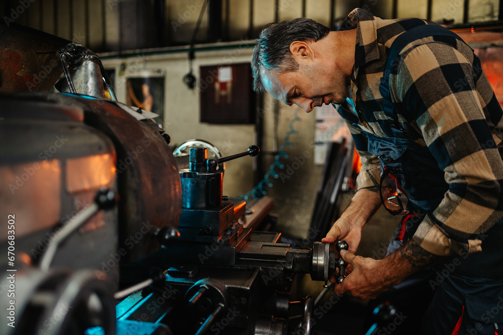 An engineer examining a knob on a factory machine, repairing, fixing. An engineer examining a knob on a factory machine, repairing, fixing.