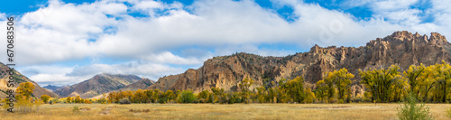 Panorama of an Absaroka Mountain Valley with Early Morning Light in Fall Color on a Cloudy Autum Day on the Road from Cody, Wyoming, USA to Yellowstone National Park