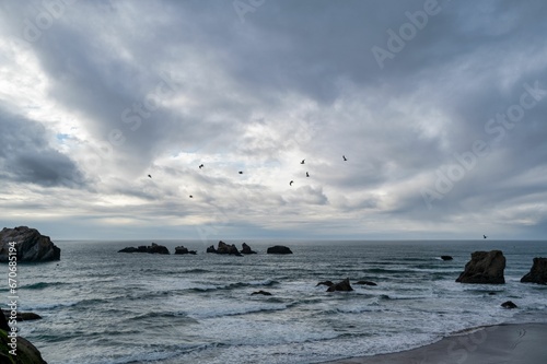 Vibrant beach landscape featuring an overcast sky, a tranquil body of water