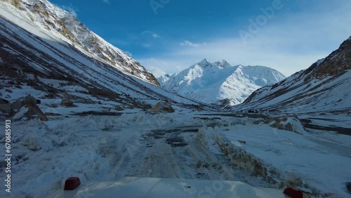 A snowy Shinkula Drive from a jeep’s front glass, showcasing white mountains and winding snowy roads, offering a thrilling view of the high-altitude journey through the pass. photo