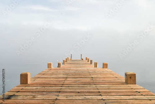 muelle de madera entre la niebla © Marina