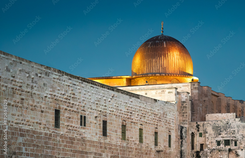 Al Aqsa Mosque on the Temple Mount in the Old Town of Jerusalem, Israel. View on the ancient mosque along southern wall of al-Haram al-Sharif, silver dome of Al-Aqsa in evening gold illumination.