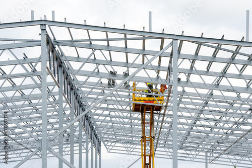Fotografie Complex large volume steel frame structure assembly using self propelled scissor