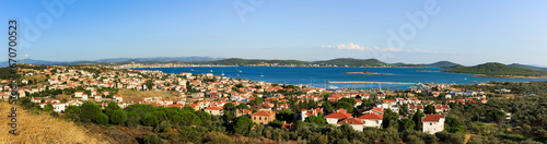 Panoramic view of Cunda Island showcasing terracotta-roofed houses, lush greenery, and the sparkling Aegean Sea.  photo