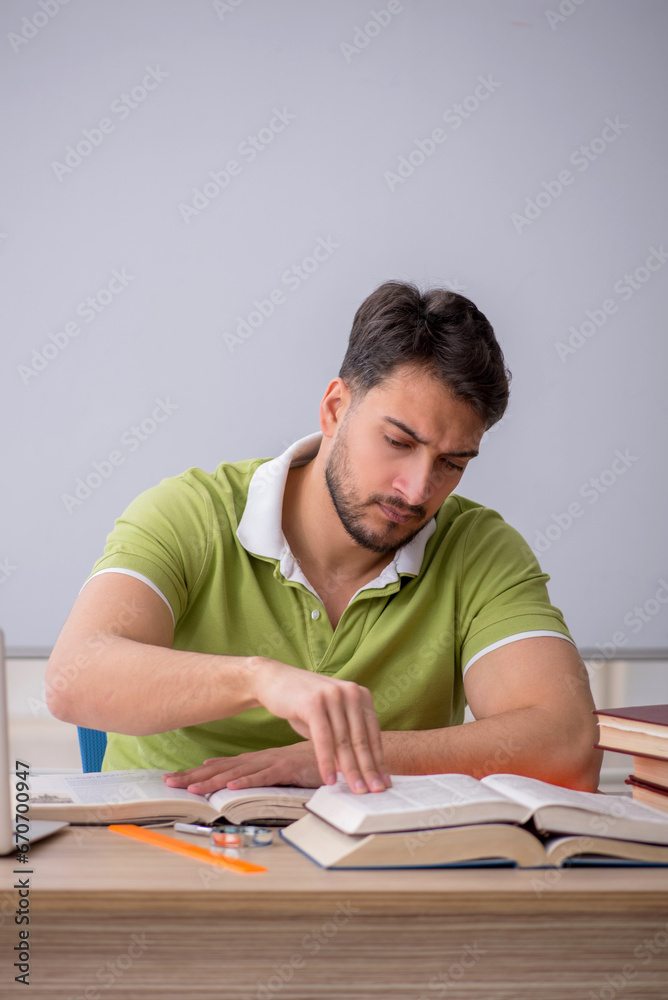 Young male student sitting in front of whiteboard Young male student sitting in front of whiteboard