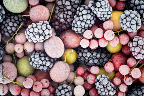 Frozen berries fruits as background, top view. Fruits with hoarfrost. Mix of different frozen berries. photo
