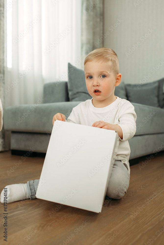 Child Playing. Boy holding a cardboard box and smiling Child Playing. Boy holding a cardboard box and smiling