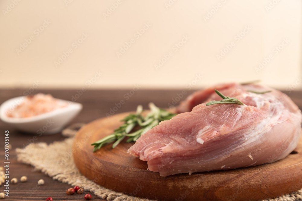 Raw pork with herbs and spices on a brown wooden. Side view, selective focus.