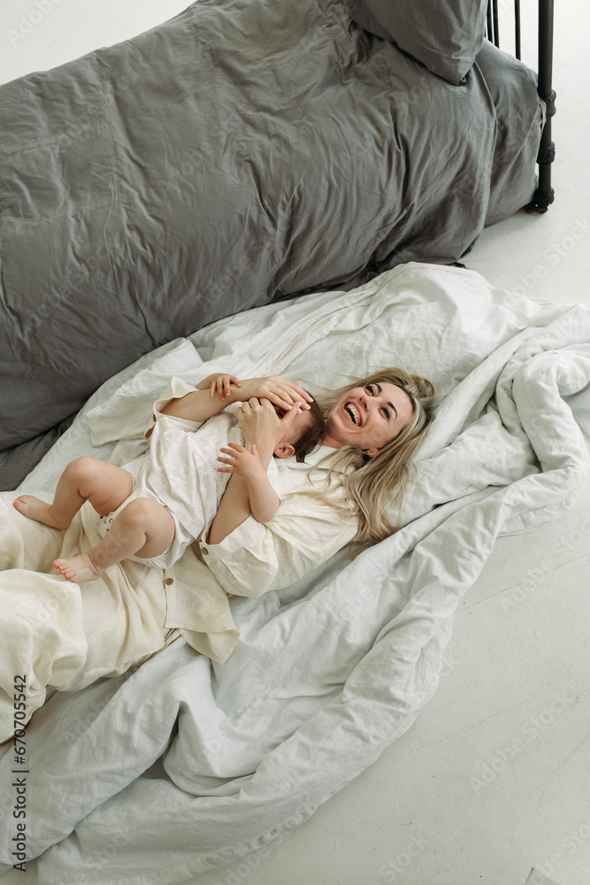 Mom and little daughter are lying on a blanket, playing. Mom and little daughter are lying on a blanket, playing.