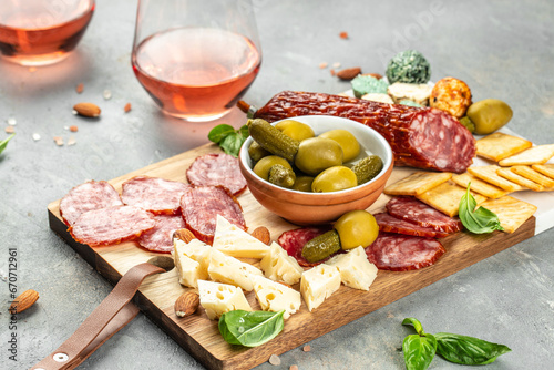 Cutting board with salami, cheese, bread and olives on light stone background. banner, menu, recipe place for text, top view