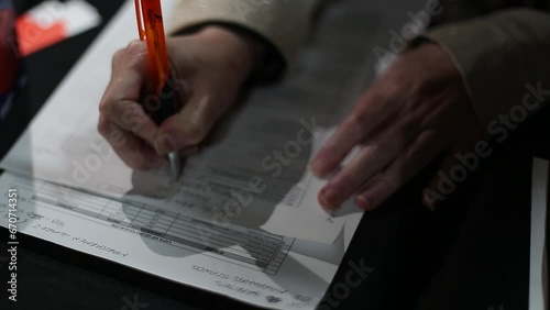 manos femeninas  escribiendo en una hoja de papale photo